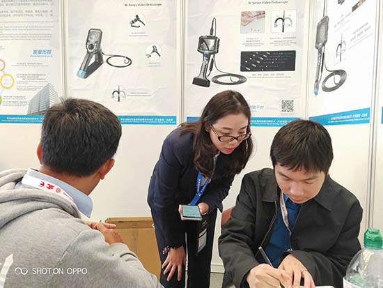 亞泰光電展臺前,公司內窺鏡工程師與客戶親密交談為